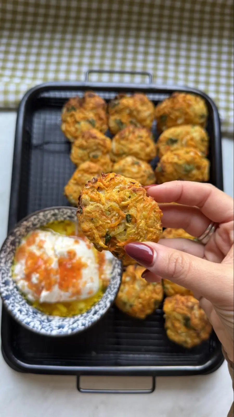 יד אוחזת לביבת ירק קריספית מעל התבנית והמטבל